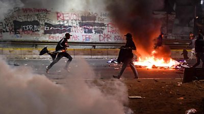 Protesters, tear gas and burning debris in Jakarta