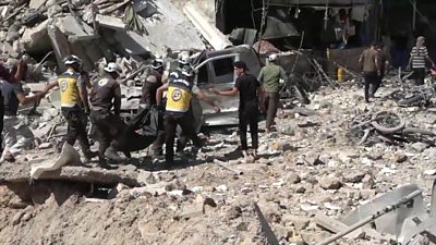Rescuers helping after a reported air strike in Idlib