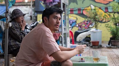 A young Vietnamese man smokes a cigarette