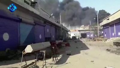 Smoke rises from a building in the Syrian border town of Ras al-Ain