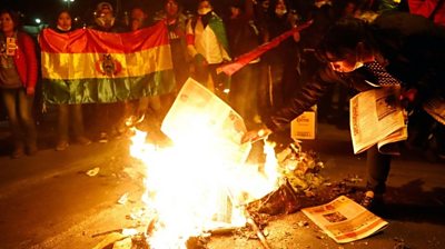 Protesters burn newspapers during a march in La Paz