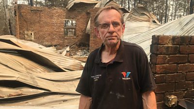 Warren Smith in front of his burnt-down home