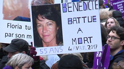 Protesters in Paris hold a picture of a victim of domestic violence