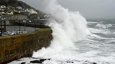 A huge wave hitting a harbour wall