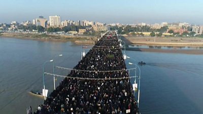 Mourners walk over a bridge in Ahvaz