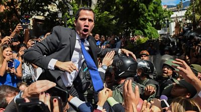 Venezuelan opposition leader Juan Guaido shouts surrounded by journalists on his way to the National Assembly