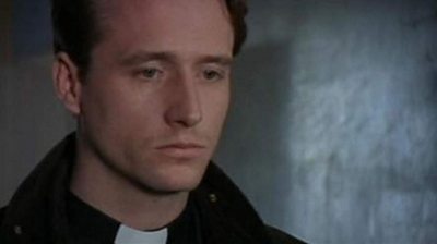 A young handsome priest looks deep in thought