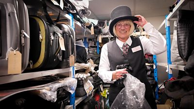 Gill Miles wearing a lost top hat at Transport for Wales' lost property office in Newport