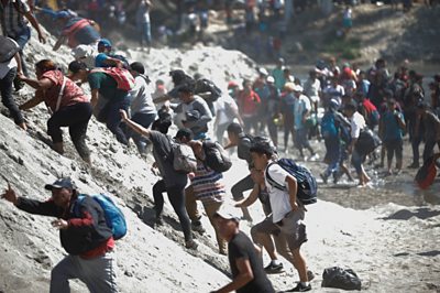 Migrants cross a river between Guatemala and Mexico