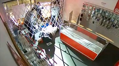 A burglar in a phone shop in Vancouver had to wait for police to get him past the security fence.