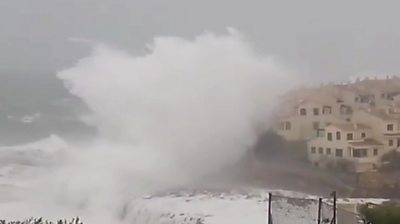 Waves crash against houses on Spanish coast