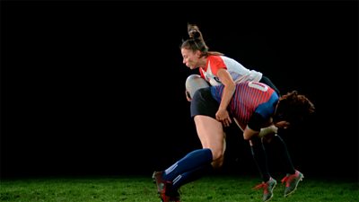 Two rugby players in a tackle