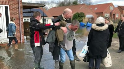 Man piggy-backed to safety from flooding