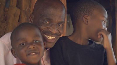 Father with two kids outside their home in Kibera