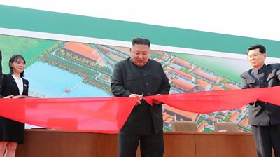 Kim Jong-un cutting ribbon at factory opening