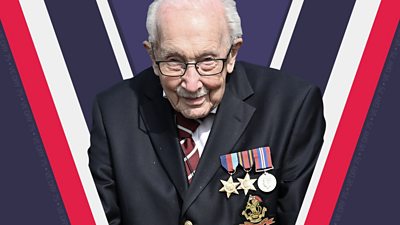 Captain-Tom-Moore-stands-wearing-his-medals