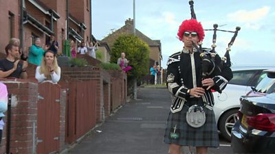 Person playing bagpipes in the street