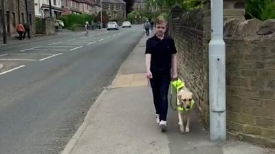 Louis walking down street with guide dog