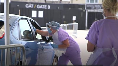 Medics conduct a test at a drive-through