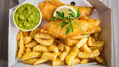 Fish and chips with peas and slice of lemon and garnish