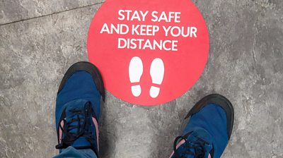 sign-on-floor-saying-stay-safe-and-keep-your-distance