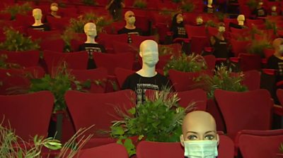 Dummies in masks in a theatre