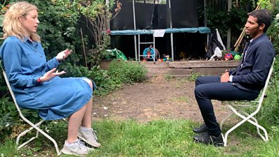 Two people sitting, socializing in a garden