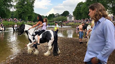 Roma presenter and writer Damian Le Bas (right) at the Appleby Horse Fair, June 2018 looking at a woman and girl on a horse,