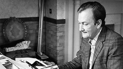 Writer Johnny Speight right of photo at a desk on a typewriter