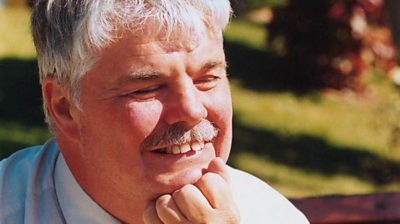 Peter White smiling, with chin resting on his hand