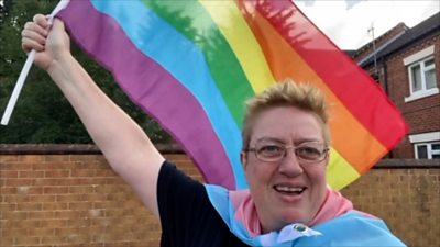 Julie Bremner holding the rainbow Pride flag