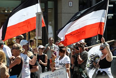 Protesters carry the flag of the pre-World War One German Empire at the Berlin protest