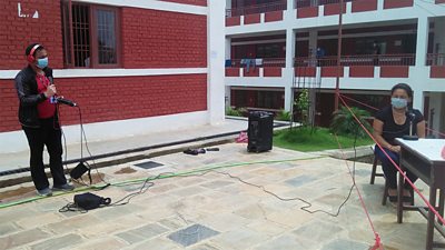 Wearing face mask and also maintaining physical distancing, Milijuli Nepali producer Prakash Sundas interviewing a woman in a quarantine centre near Kathmandu.