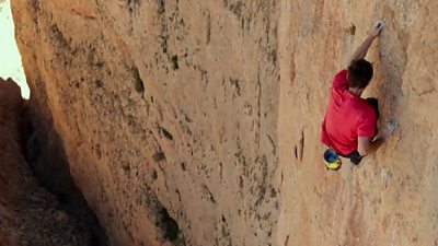 A man free solo climbing (climbing without ropes)