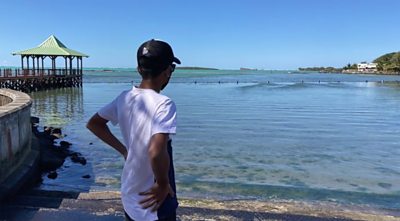 Young man looking at the oil spill on the beach