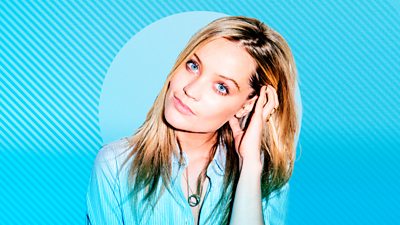 5 Live's Laura Whitmore head and shoulders with her left hand brushing back her hair. On a Blue composite background