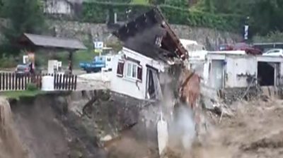 House falling into river