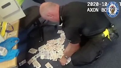A police officer and the cash from the safe