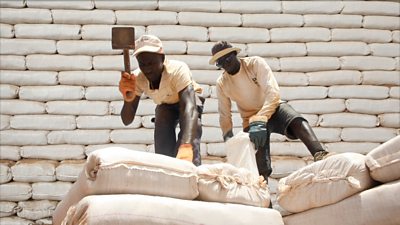 Two men using moon bricks to build a school