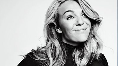 Sophie Morgan in a black and white portrait - close up on white background. Looking away from the camera thoughtfully, with a smile and her long hair slightly covering her left eye.