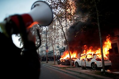 Paris: Tear gas and fires at protest against police violence - BBC News