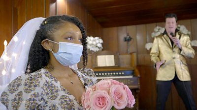 Reporter Alana Yzola holds some pink roses in a mock wedding. An Elvis impersonator is in the background.