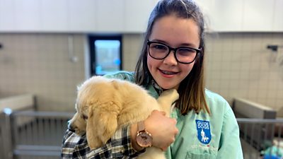 Caitlin holds a guide dog puppy