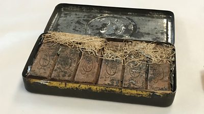 An antique tin with bars of chocolate