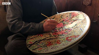 An artisan painting papier mache