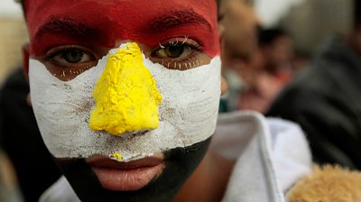 Man with face painted the colours of the Egyptian flag