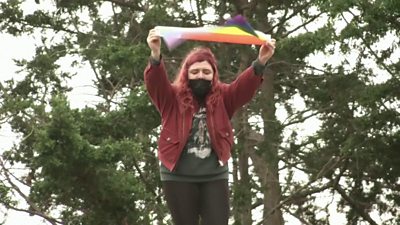 A protester holds an LGBT flag