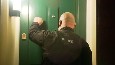 A police officer knocking on a door