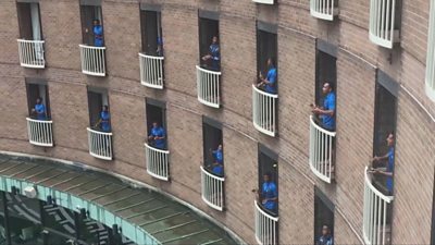 Rugby team singing from individual hotel balconies