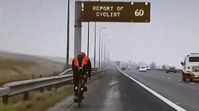 A cyclist who was illegally on the motorway rode past a cycling warning message.